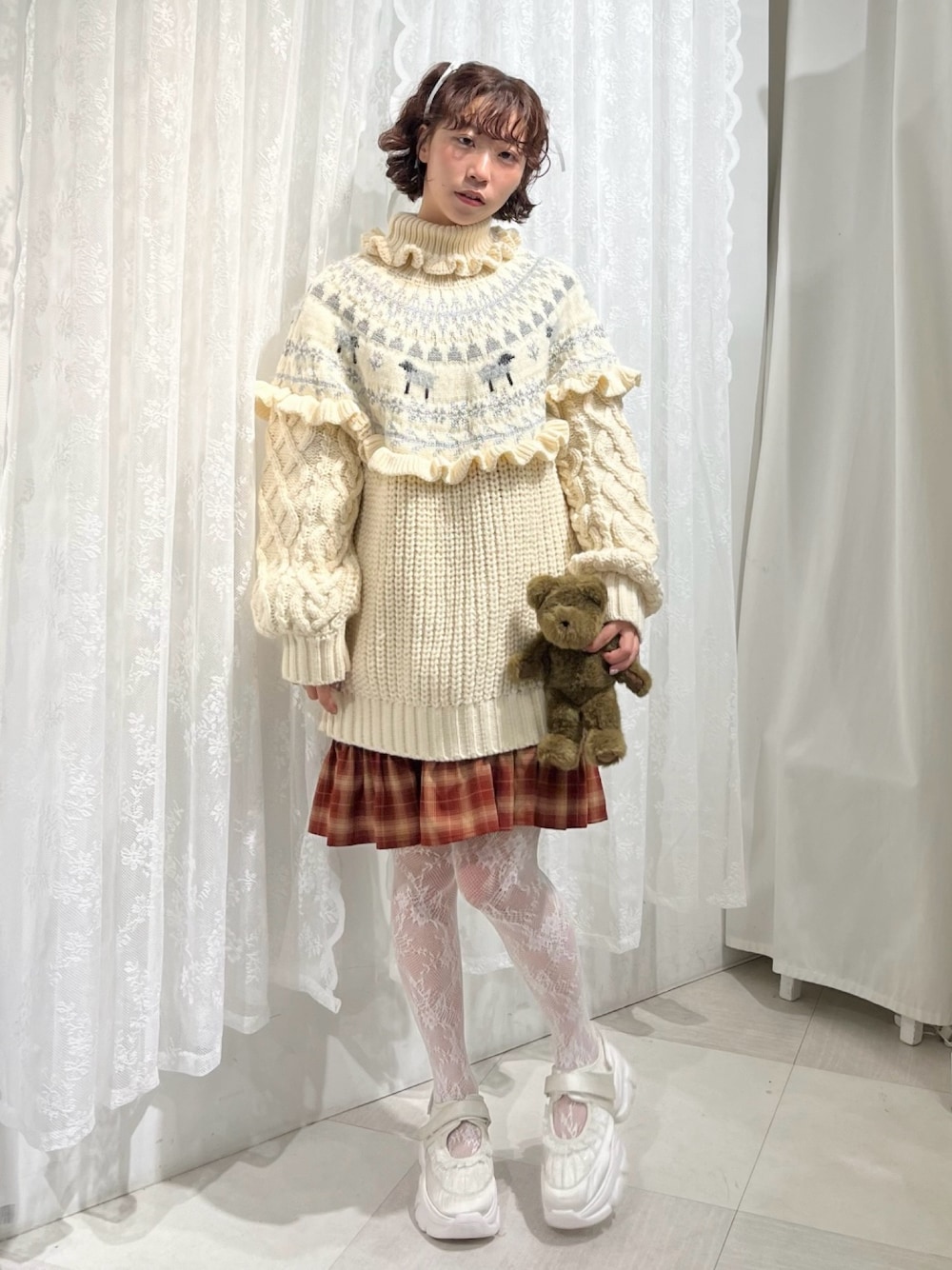 ホワイト系のニット/セーター、レッド系のワンピース、ホワイト系のスニーカーを着用したレディースの秋コーディネートの1枚目の写真