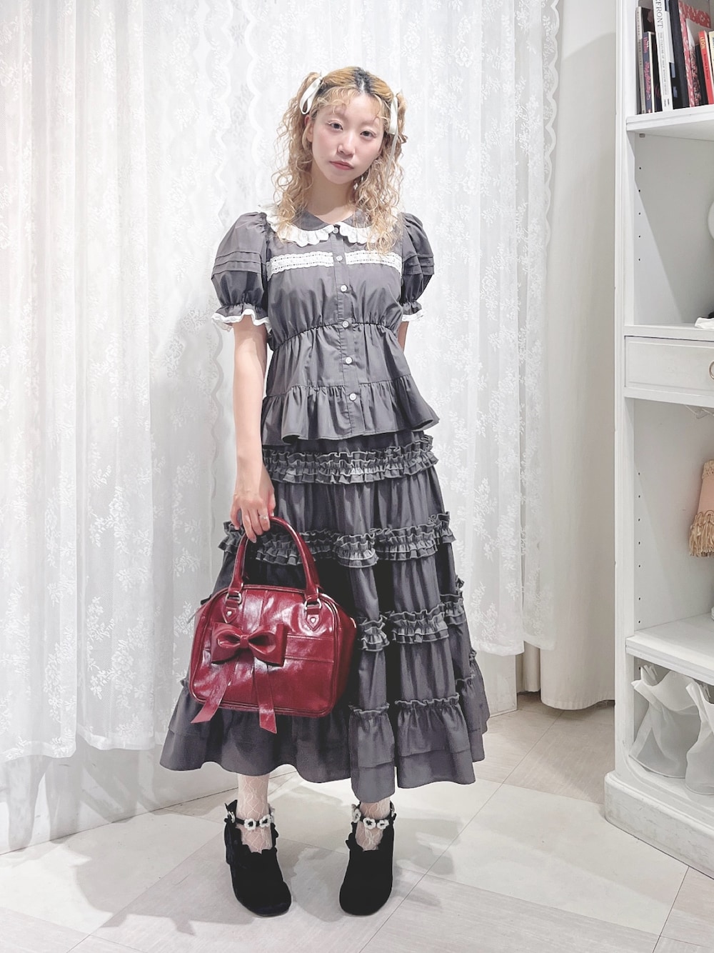 グレー系のシャツ/ブラウス、グレー系のスカート、レッド系のハンドバッグを着用したレディースの夏コーディネートの1枚目の写真