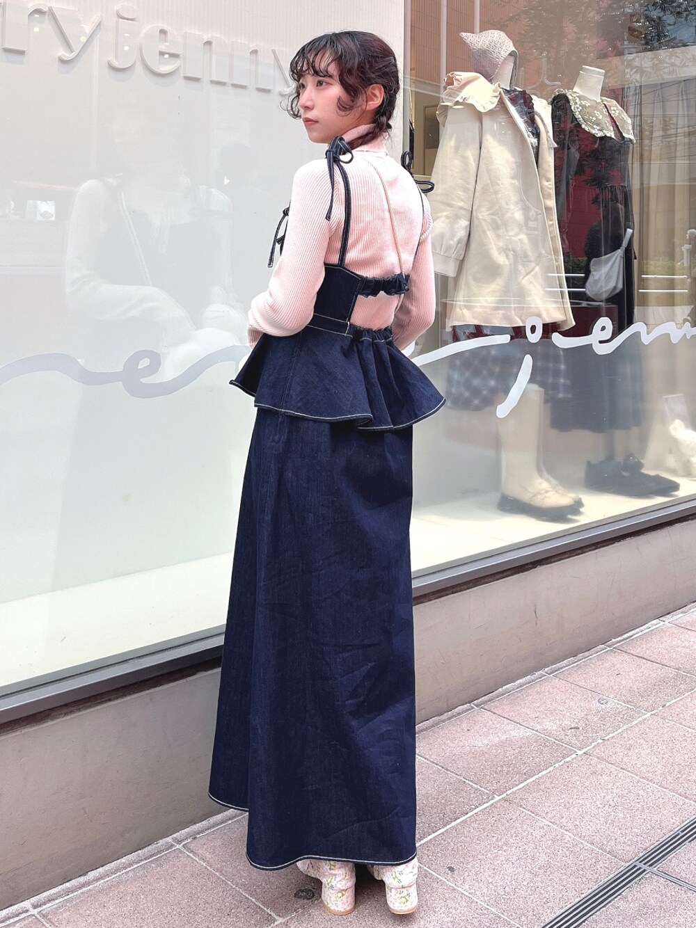 ピンク系のニット/セーター、ブルー系のワンピース、ホワイト系のショルダーバッグを着用したレディースの冬コーディネートの1枚目の写真