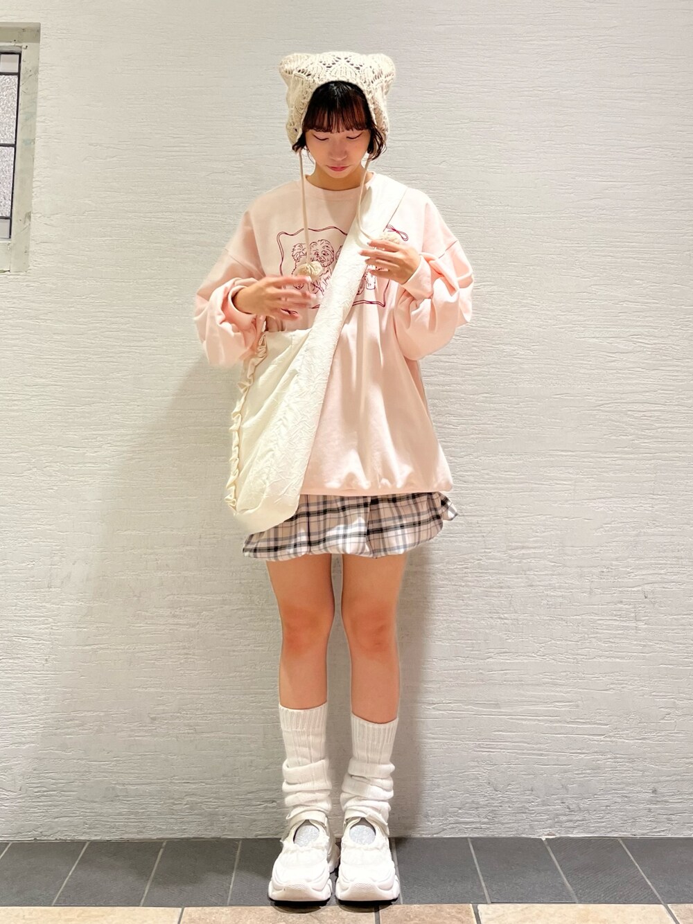 ピンク系のスウェット、ベージュ系のスカート、ホワイト系のトートバッグを着用したレディースの秋コーディネートの1枚目の写真