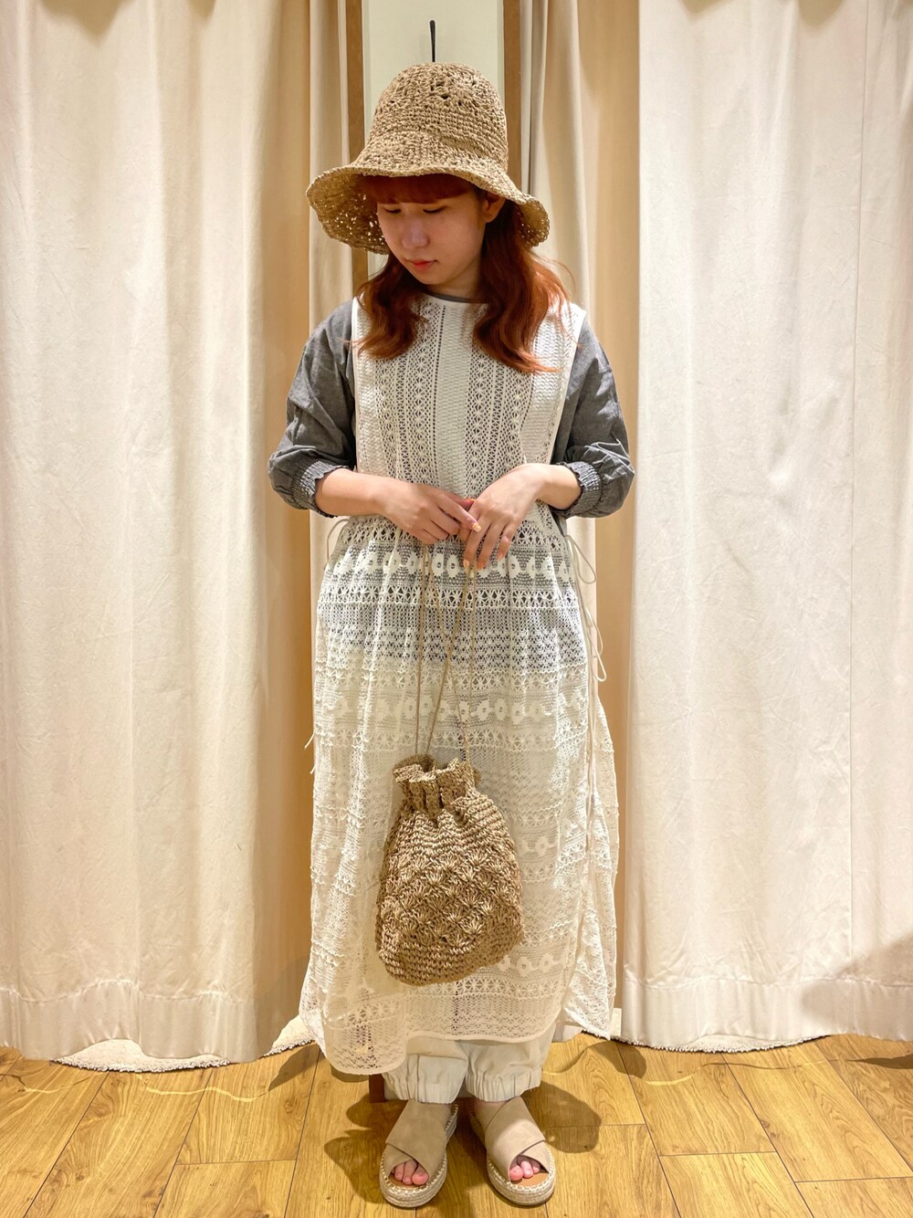 ベージュ系のエコバッグ/サブバッグ、ホワイト系のワンピース、ベージュ系のサンダルを着用したレディースの春コーディネートの1枚目の写真