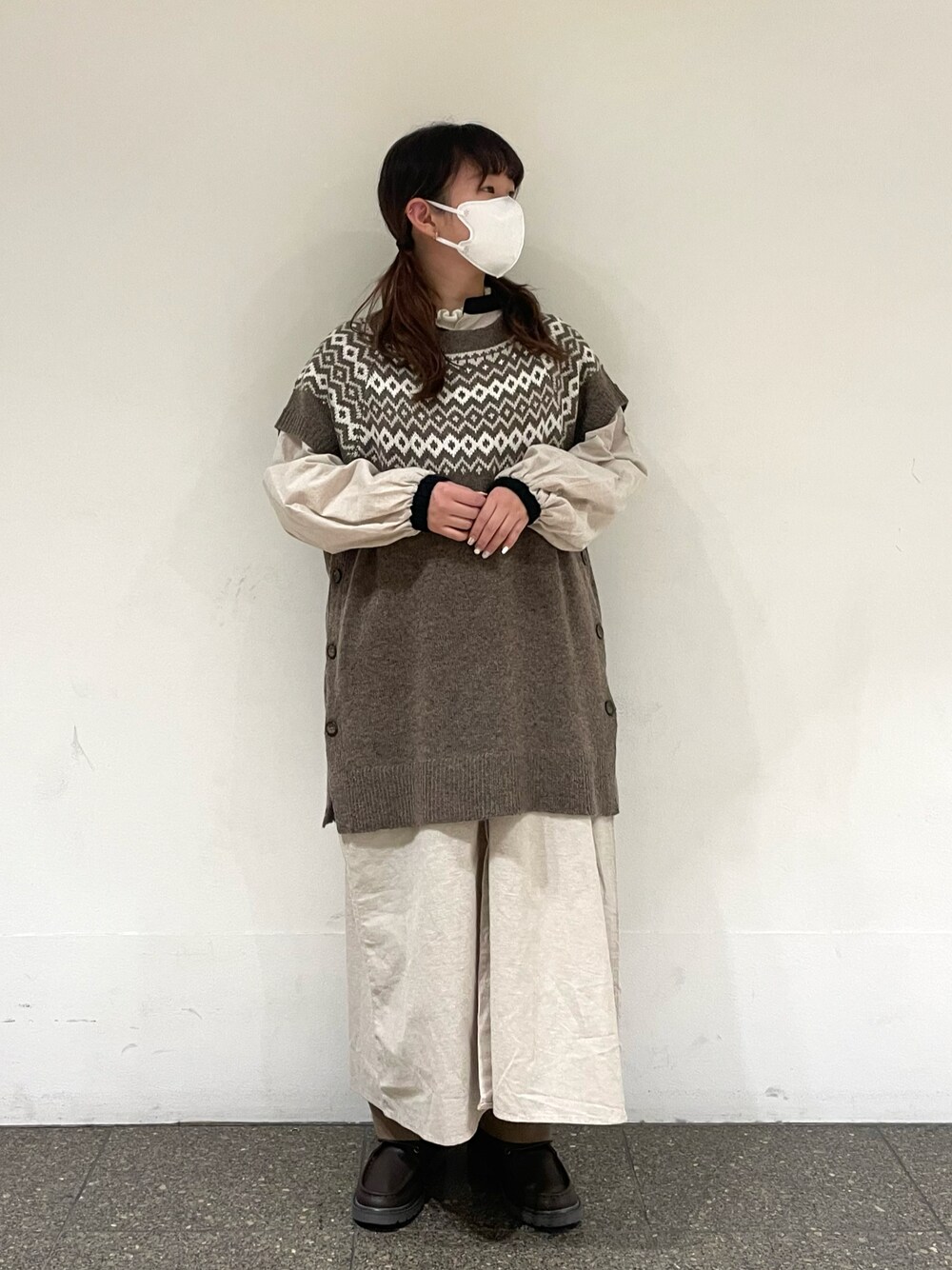 ベージュ系のワンピース、ブラウン系のベスト、ブラウン系のその他パンツを着用したレディースの冬コーディネートの1枚目の写真