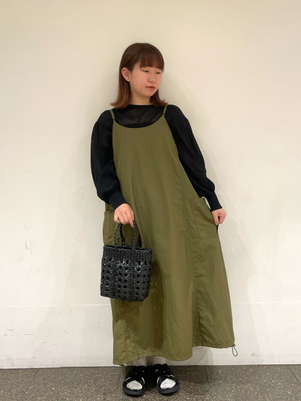 ブラック系のカーディガン/ボレロ、グリーン系のワンピース、グレー系のハンドバッグを着用したレディースの夏コーディネートの1枚目の写真