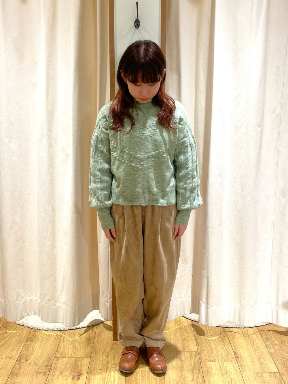 ホワイト系のシャツ/ブラウス、グリーン系のニット/セーター、ベージュ系のその他パンツを着用したレディースの冬コーディネートの1枚目の写真