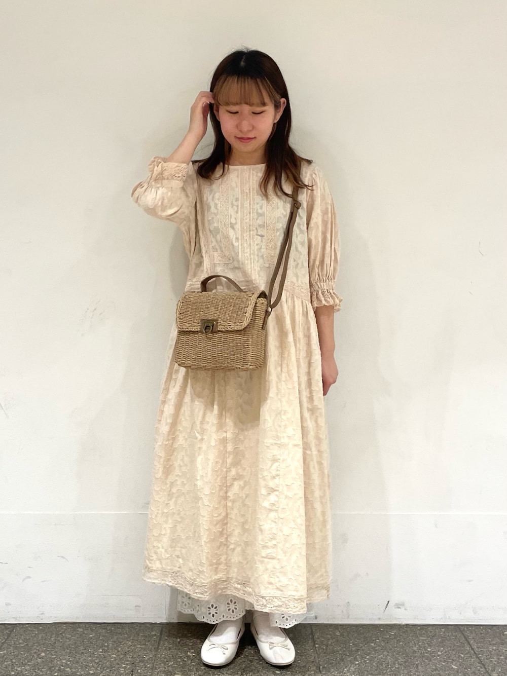 ホワイト系のパンプス、ホワイト系のワンピース、ベージュ系のハンドバッグを着用したレディースの春コーディネートの1枚目の写真