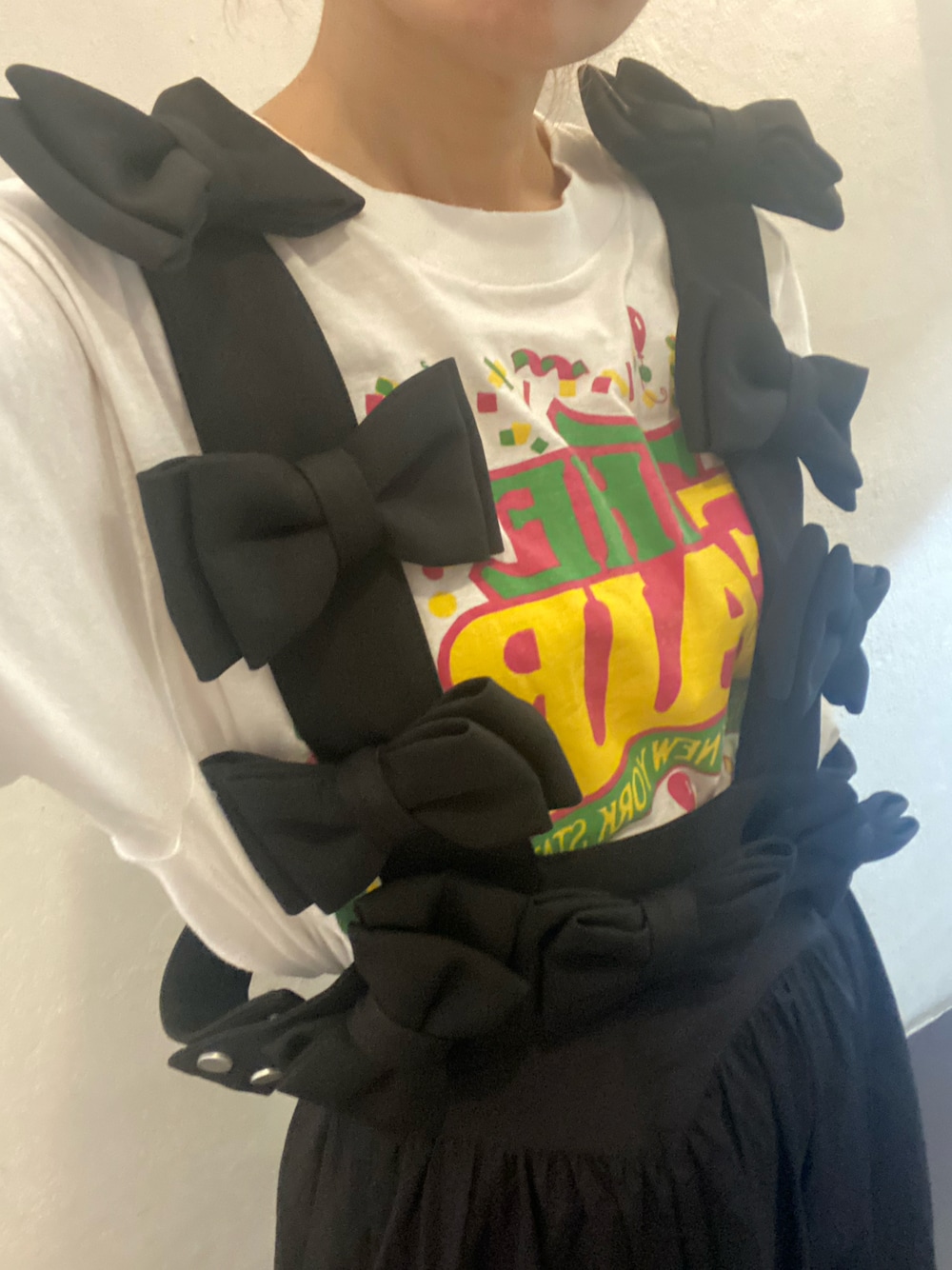 ホワイト系のTシャツ/カットソー、ブラック系のスカート、ブラック系のサスペンダーを着用したレディースの夏コーディネートの1枚目の写真