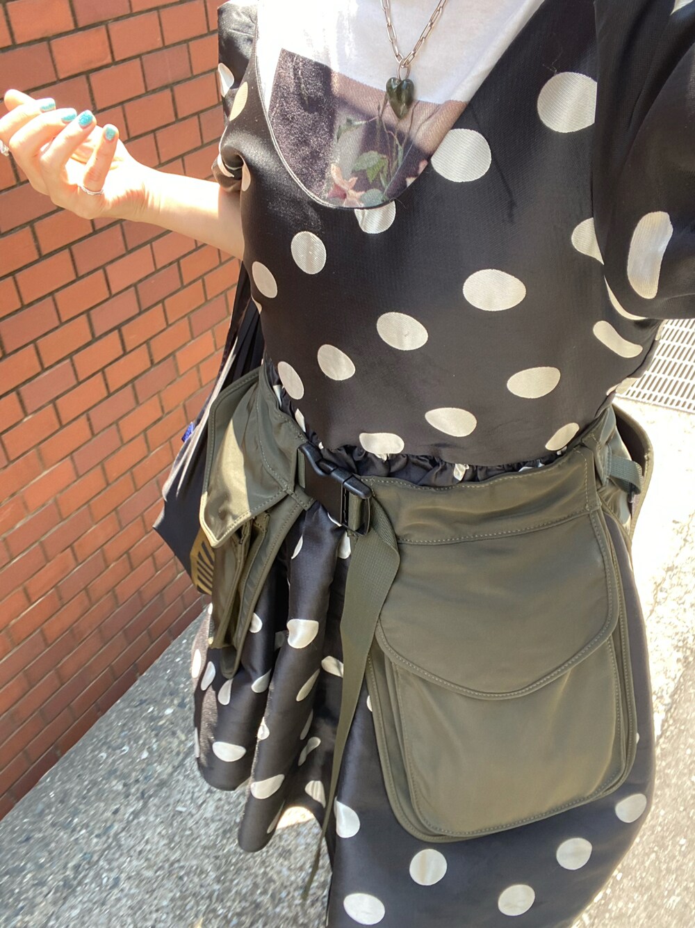 ブラック系のワンピース、グリーン系のボディバッグ/ウエストポーチを着用したレディースの夏コーディネートの1枚目の写真