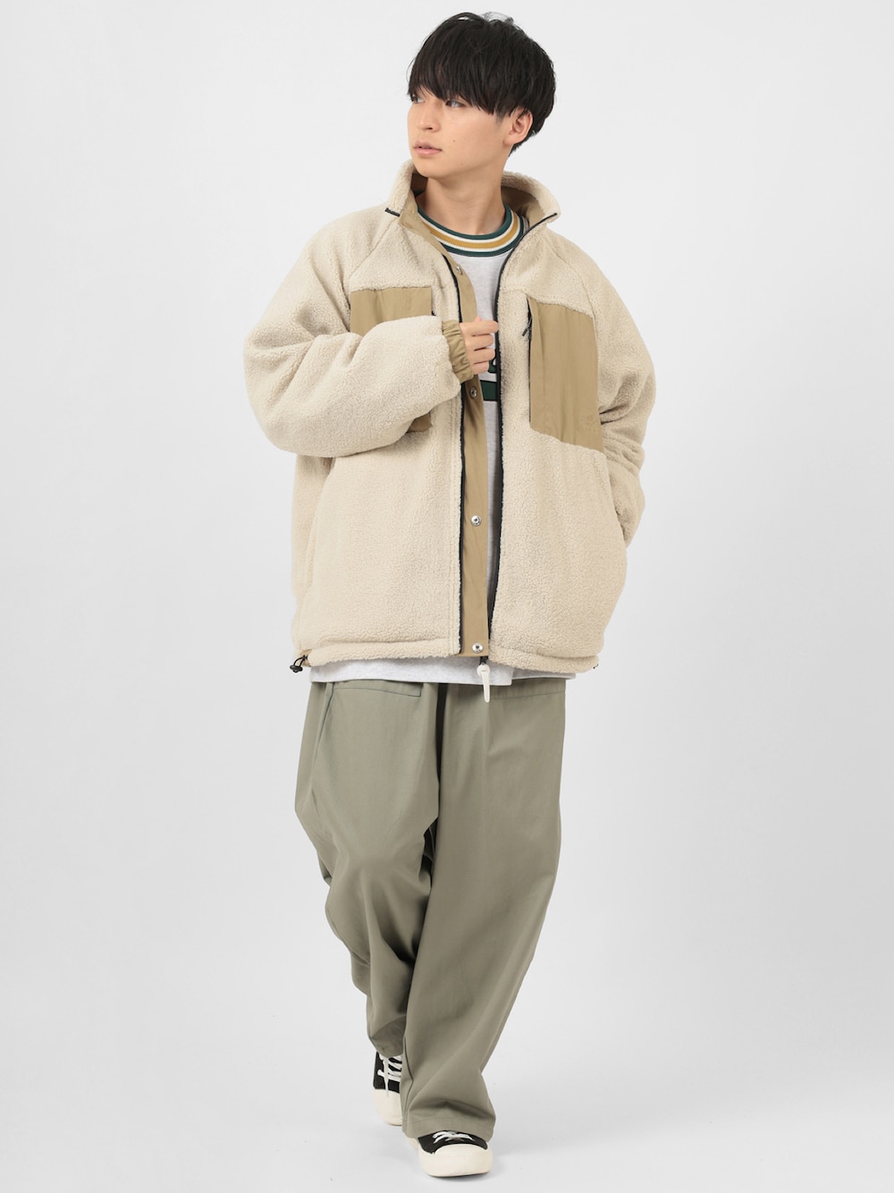 ベージュ系のマウンテンパーカー、ホワイト系のスウェットを着用したメンズの冬コーディネートの1枚目の写真