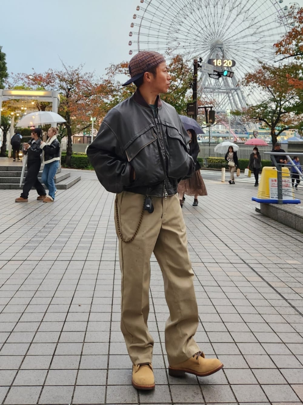 ブラウン系のブルゾン、グリーン系のスウェット、ベージュ系のチノパンツを着用したメンズの秋コーディネートの1枚目の写真