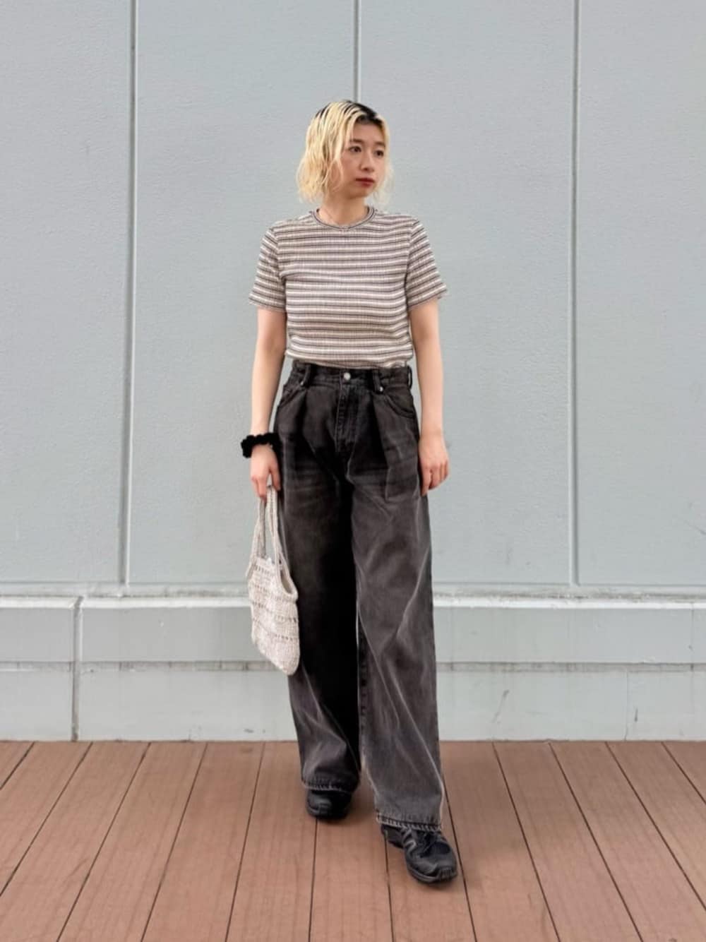 シルバー系のトートバッグ、ホワイト系のTシャツ/カットソー、ブラック系のデニムパンツを着用したレディースの夏コーディネートの1枚目の写真