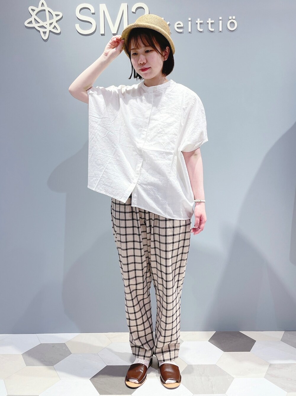 ベージュ系のその他パンツ、ブラウン系のサンダル、ホワイト系のTシャツ/カットソーを着用したレディースの夏コーディネートの1枚目の写真