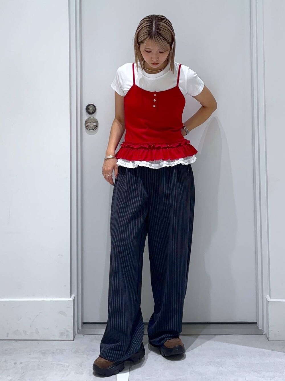 ブラウン系のモカシン/デッキシューズ、ブルー系のスラックス、ホワイト系のTシャツ/カットソーを着用したレディースの夏コーディネートの1枚目の写真