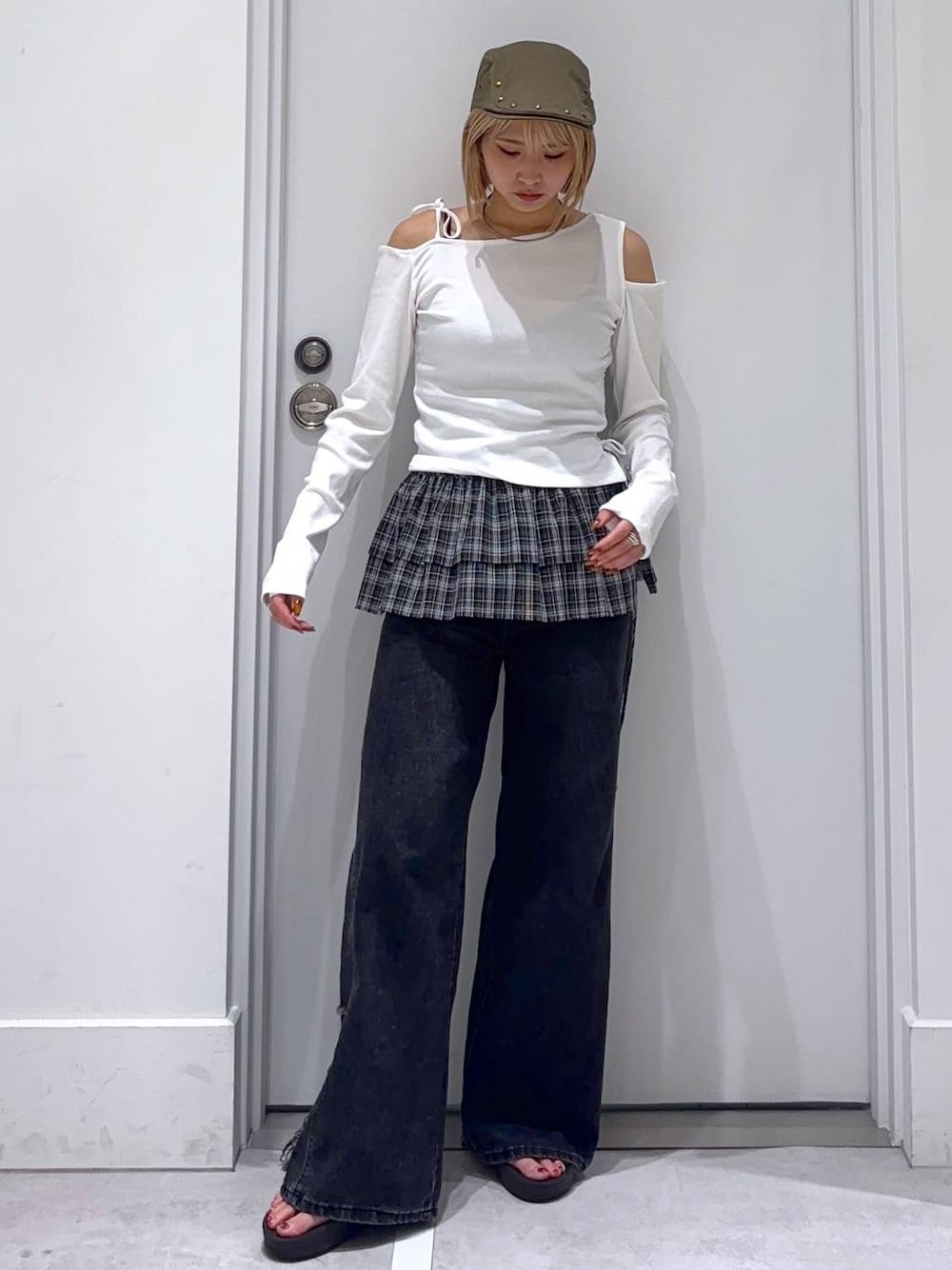 ブラック系のデニムパンツ、ホワイト系のTシャツ/カットソー、グリーン系のハンチング/ベレー帽を着用したレディースの秋コーディネートの1枚目の写真