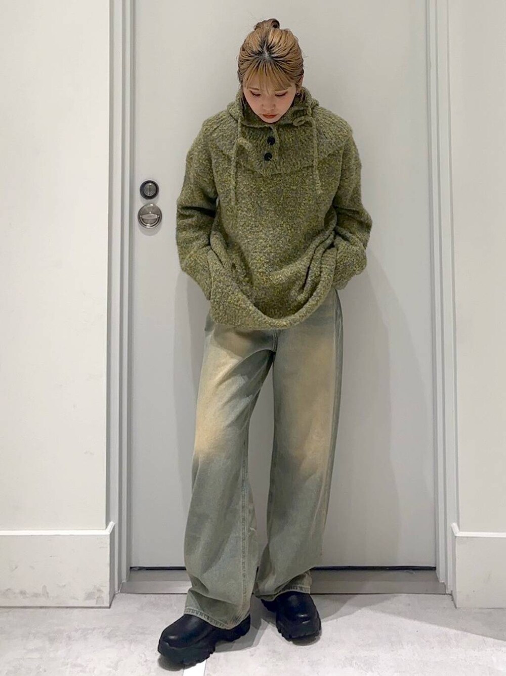 ブルー系のデニムパンツ、グリーン系のニット/セーターを着用したレディースの冬コーディネートの1枚目の写真