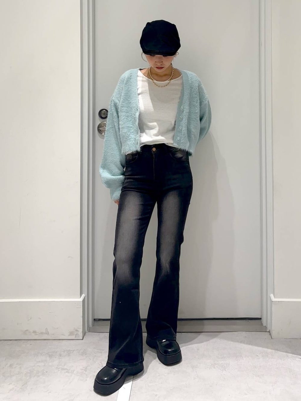 ブルー系のカーディガン/ボレロ、ブラック系のスリッポン、ブラック系のデニムパンツを着用したレディースの冬コーディネートの1枚目の写真