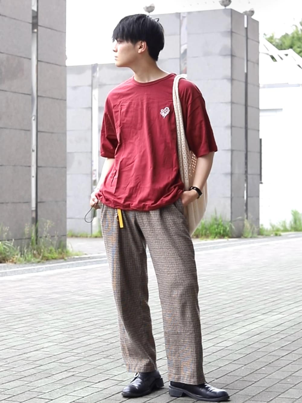 レッド系のTシャツ/カットソー、ホワイト系のトートバッグ、ベージュ系のスラックスを着用したメンズの夏コーディネートの1枚目の写真
