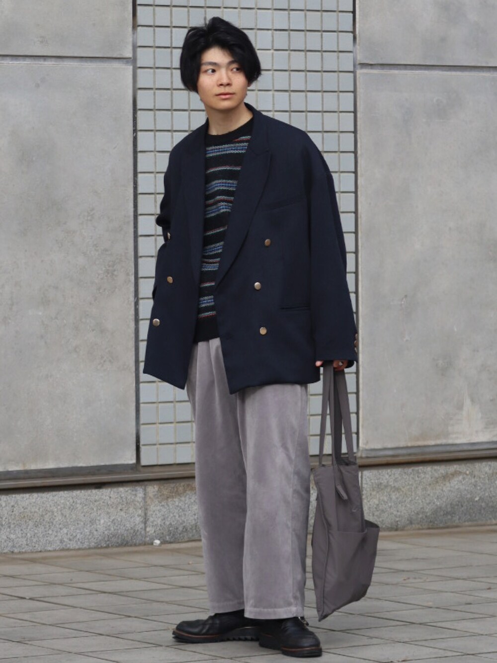 グレー系のトートバッグ、ブルー系のテーラードジャケット、ブラック系のニット/セーターを着用したメンズの冬コーディネートの1枚目の写真