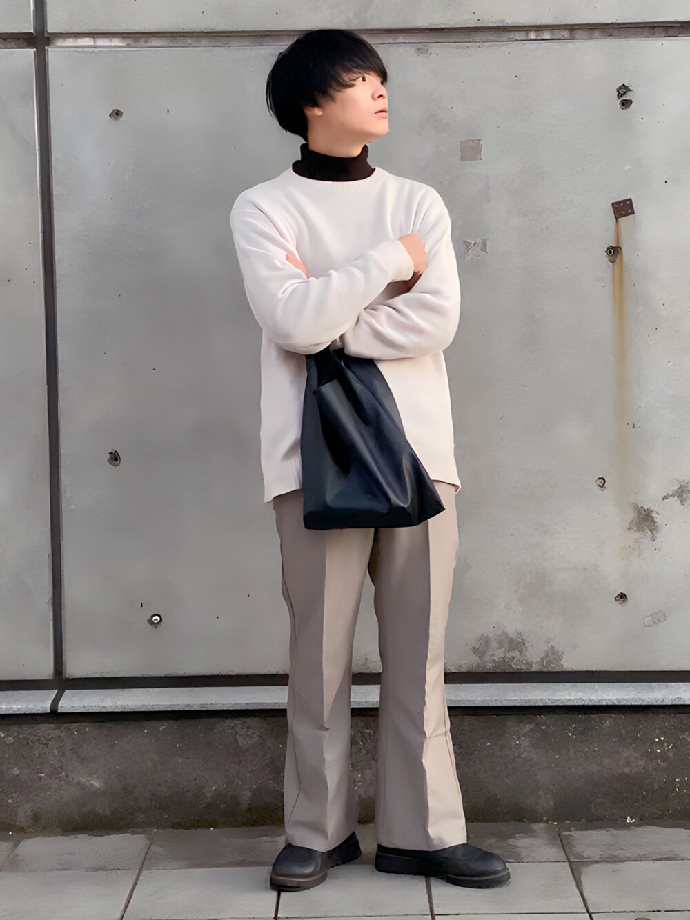 グレー系のスラックス、ブラック系のドレスシューズ、ブラック系のショルダーバッグを着用したメンズの冬コーディネートの1枚目の写真