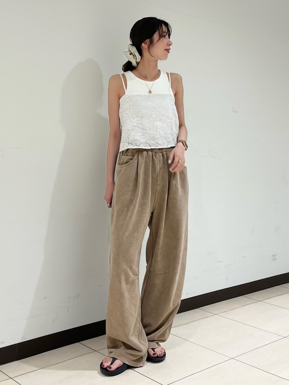 ホワイト系のキャミソール、ベージュ系のスウェットパンツを着用したレディースの夏コーディネートの1枚目の写真