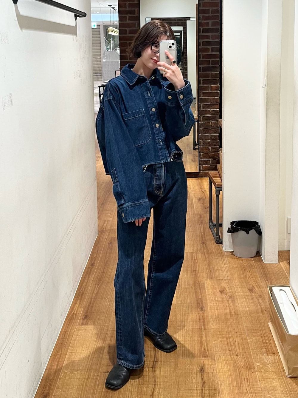 ブルー系のデニムパンツ、ブルー系のシャツ/ブラウス、ブラック系のメガネを着用したレディースの冬コーディネートの1枚目の写真