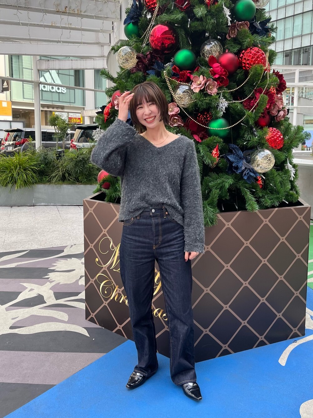 グレー系のニット/セーター、ブルー系のデニムパンツを着用したレディースの冬コーディネートの1枚目の写真