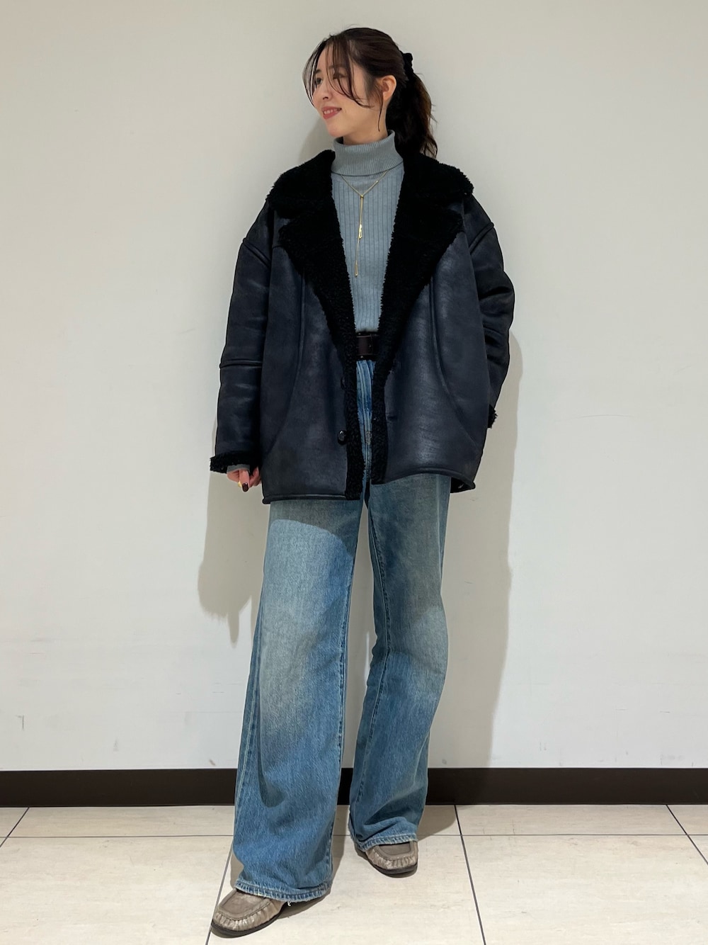 ブラック系のブルゾン、ブルー系のデニムパンツ、ベージュ系のローファーを着用したレディースの冬コーディネートの1枚目の写真