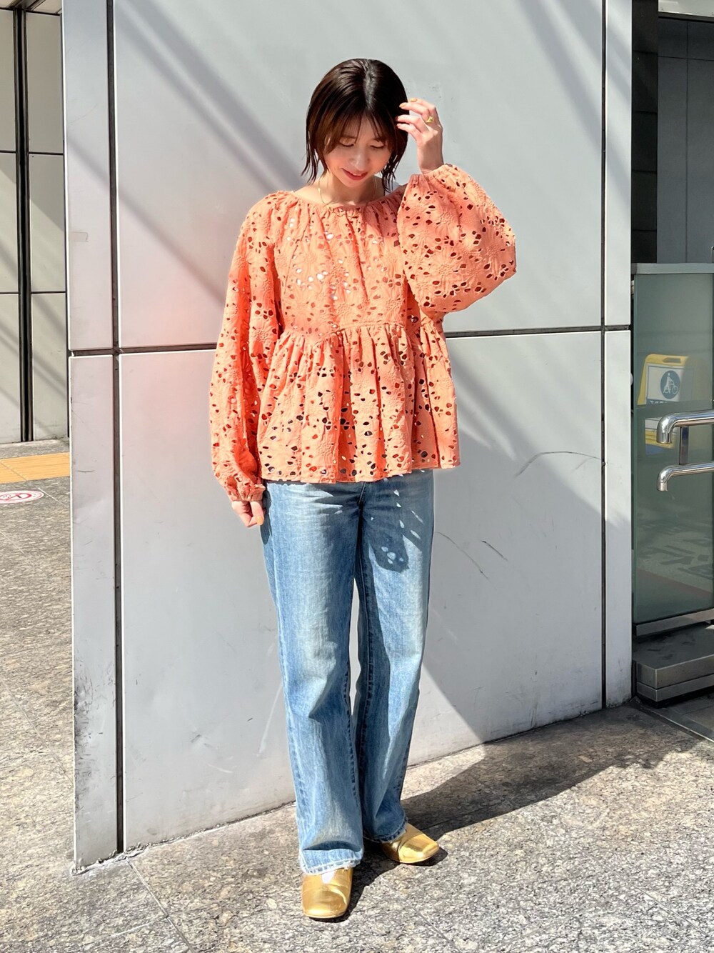 オレンジ系のシャツ/ブラウス、ブルー系のデニムパンツ、ゴールド系のパンプスを着用したレディースの冬コーディネートの1枚目の写真