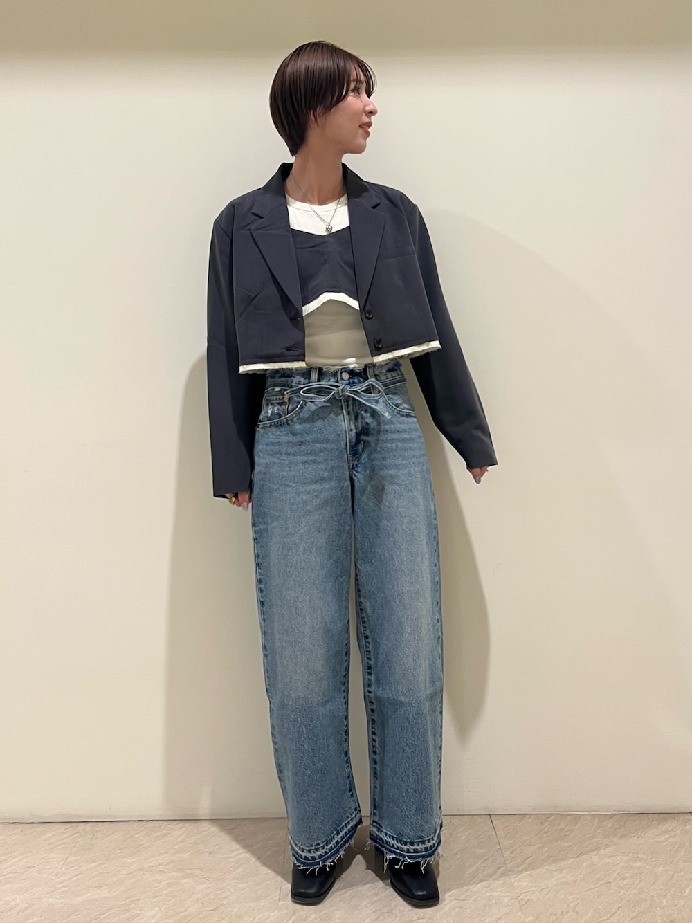 グレー系のテーラードジャケット、グレー系のキャミソール、ブルー系のデニムパンツを着用したレディースの夏コーディネートの1枚目の写真