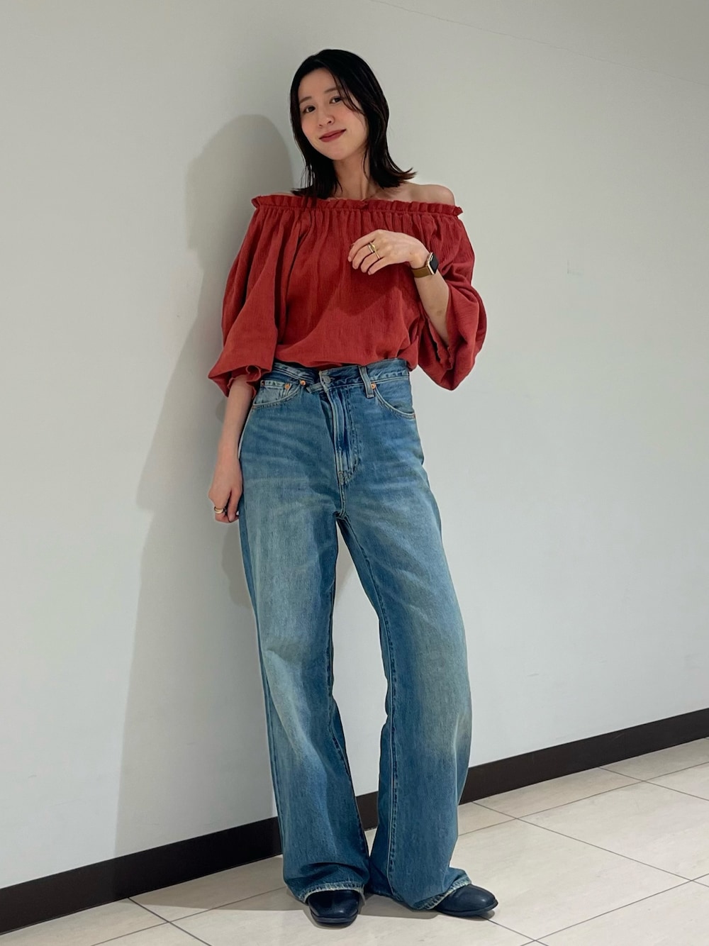 オレンジ系のシャツ/ブラウス、ブルー系のデニムパンツを着用したレディースの夏コーディネートの1枚目の写真