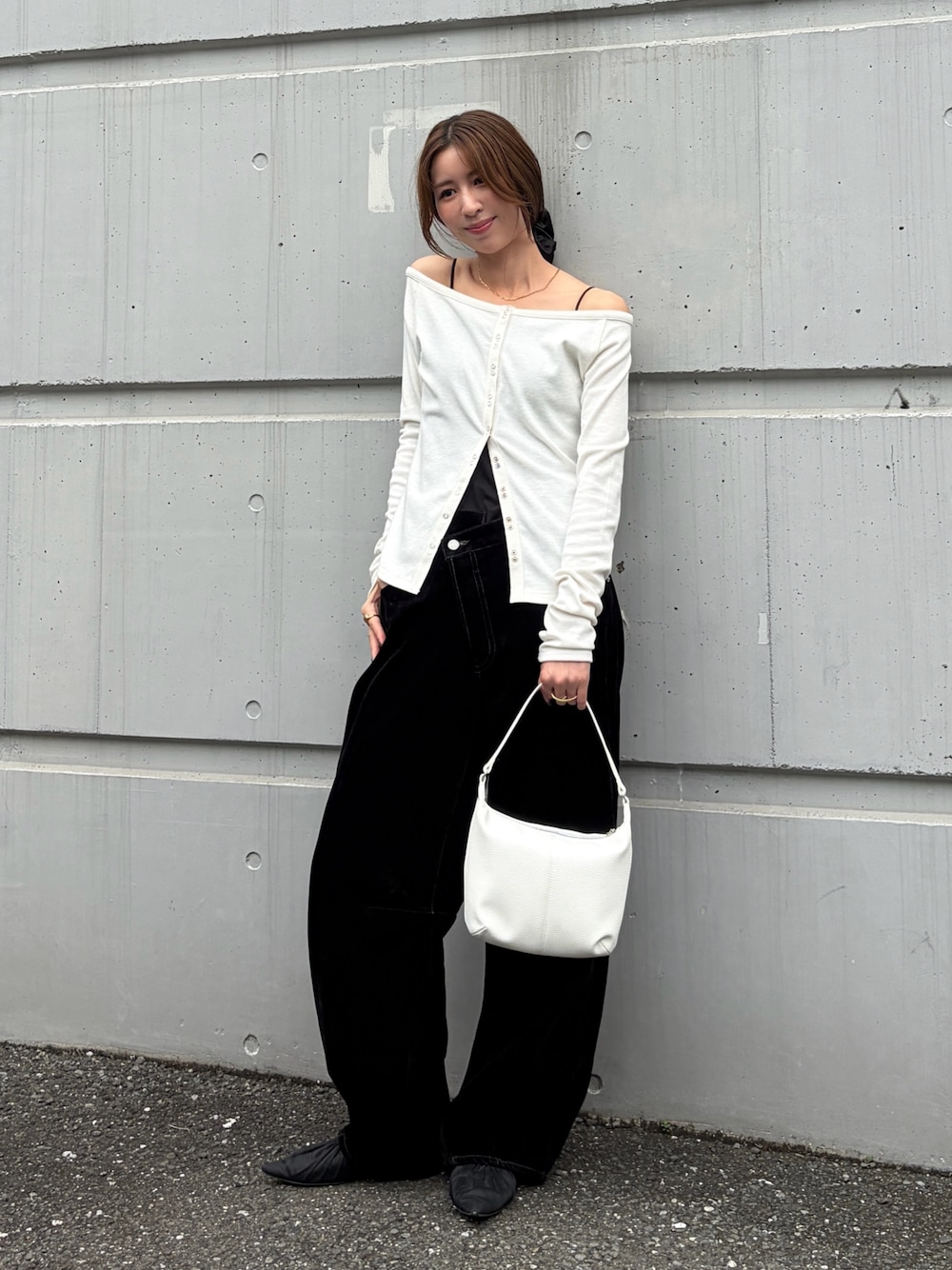 ホワイト系のTシャツ/カットソー、ブラック系のデニムパンツ、ホワイト系のハンドバッグを着用したレディースの秋コーディネートの1枚目の写真
