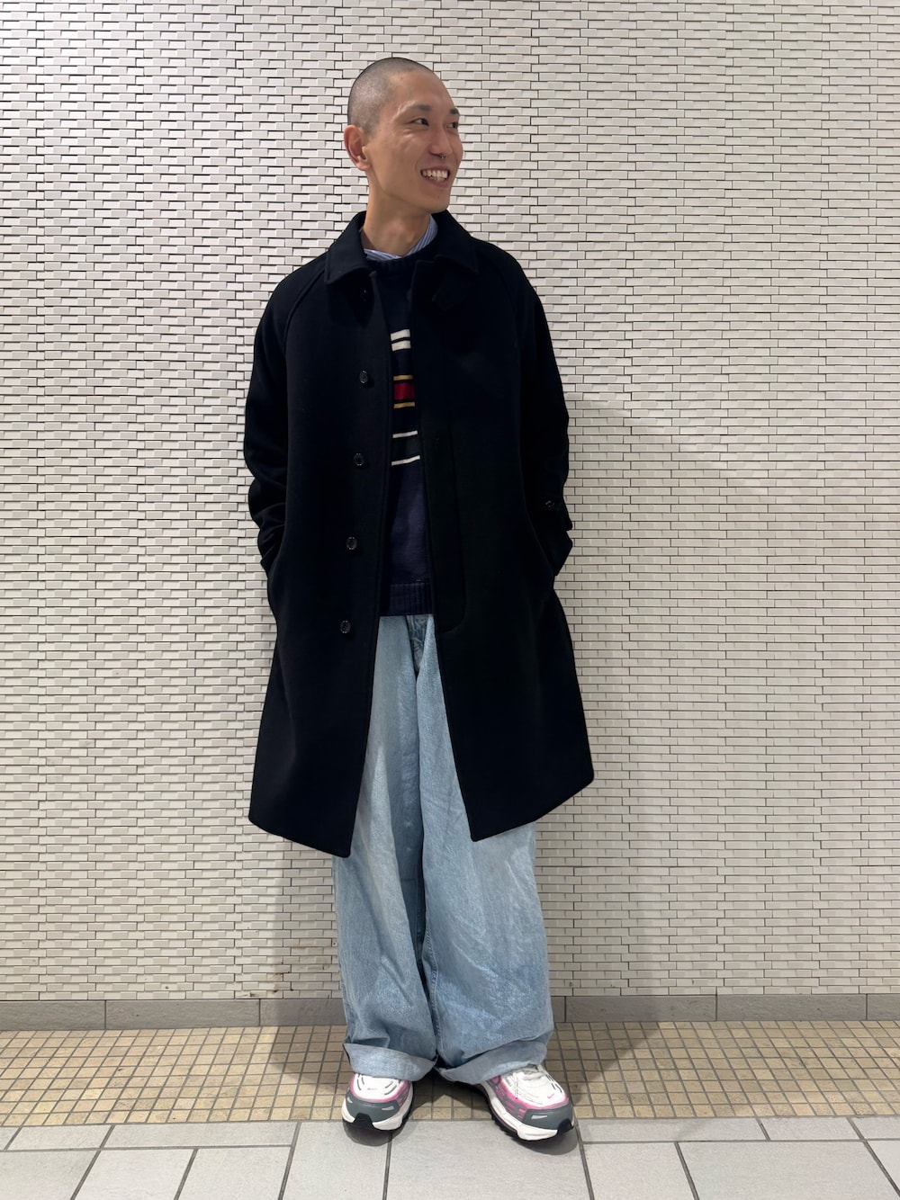 ブラック系のステンカラーコートを着用したメンズの冬コーディネートの1枚目の写真