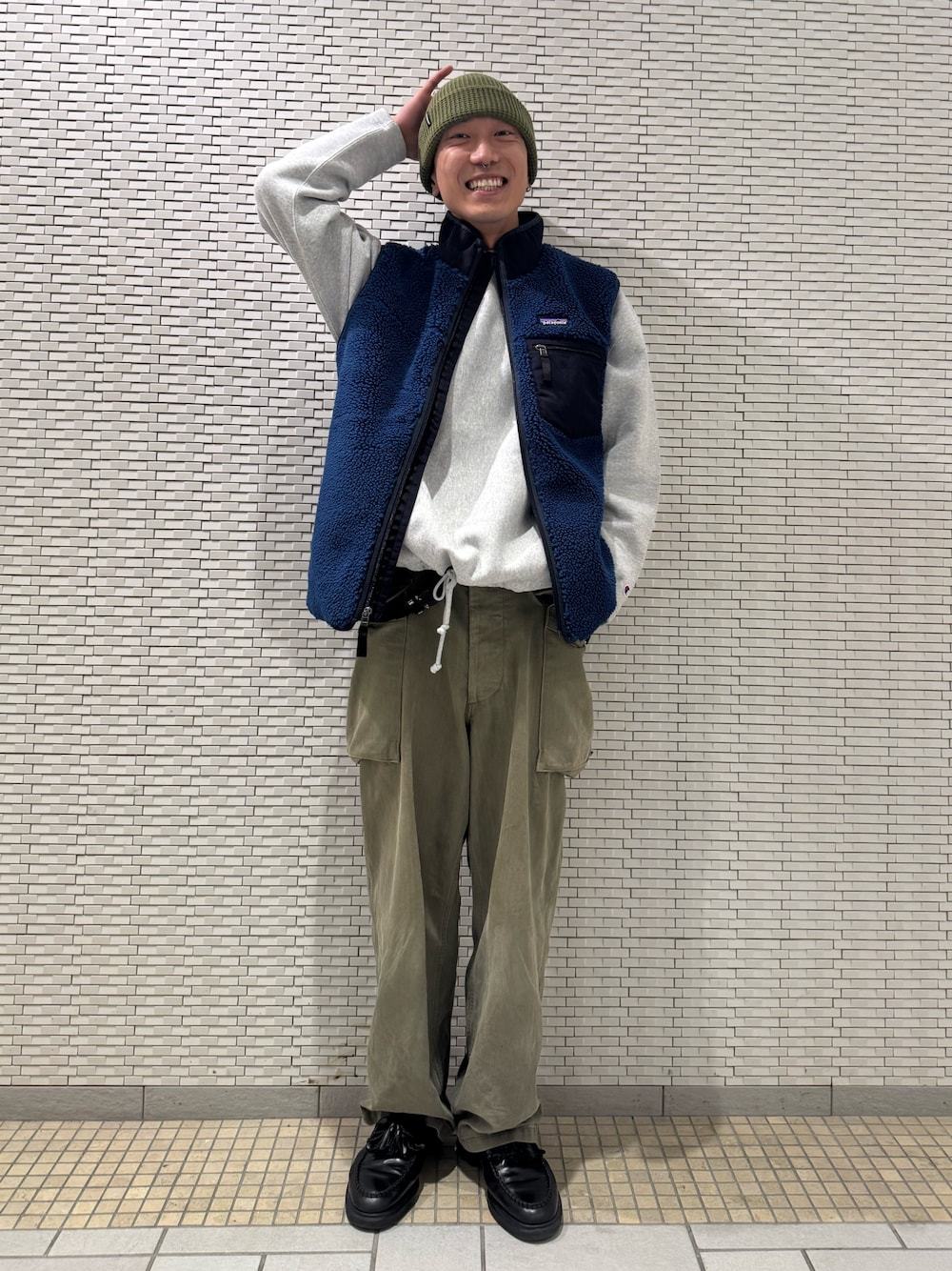 ブルー系のベスト、グレー系のスウェットを着用したメンズの秋コーディネートの1枚目の写真