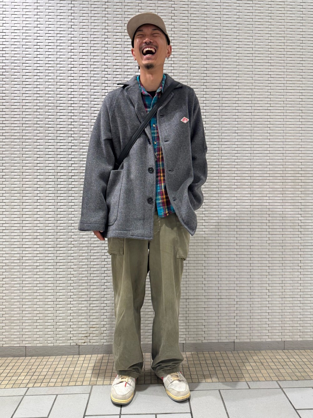 グレー系のテーラードジャケット、ベージュ系のキャップを着用したメンズの秋コーディネートの1枚目の写真