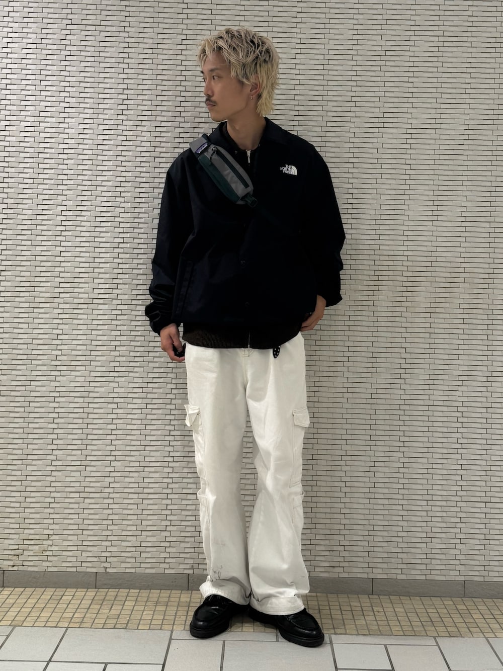 ブルー系のナイロンジャケット、ブラウン系のカーディガン/ボレロを着用したメンズの秋コーディネートの1枚目の写真