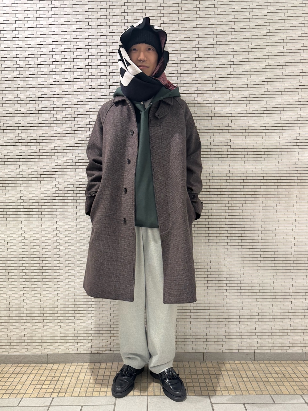 グリーン系のパーカー、その他のステンカラーコート、グレー系のその他パンツを着用したメンズの秋コーディネートの1枚目の写真