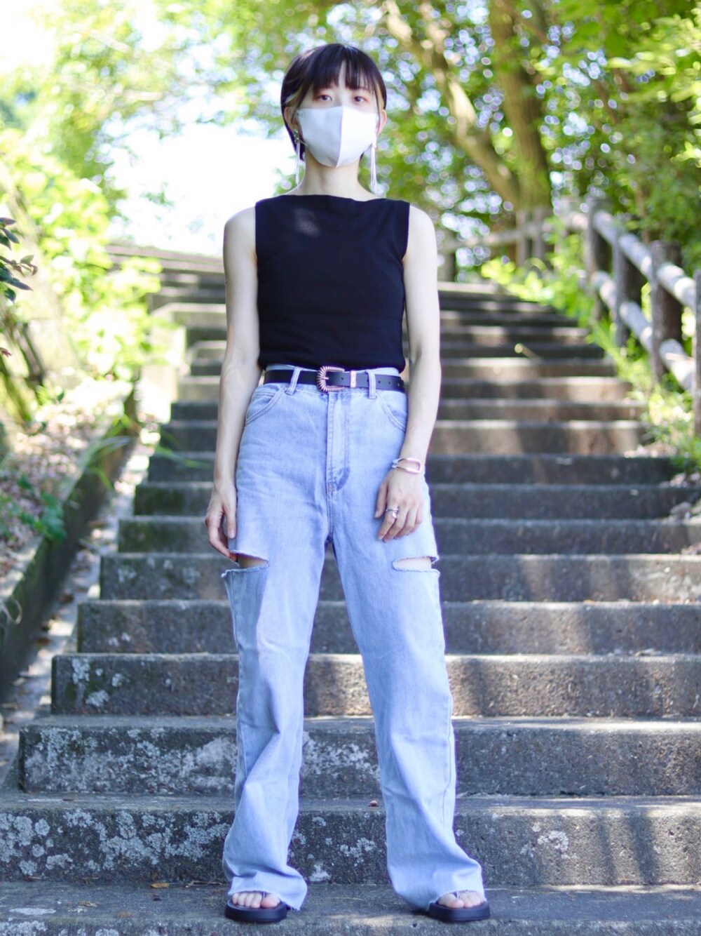 ブラック系のサンダル、ブラック系のタンクトップ、ブルー系のデニムパンツを着用したレディースの夏コーディネートの1枚目の写真