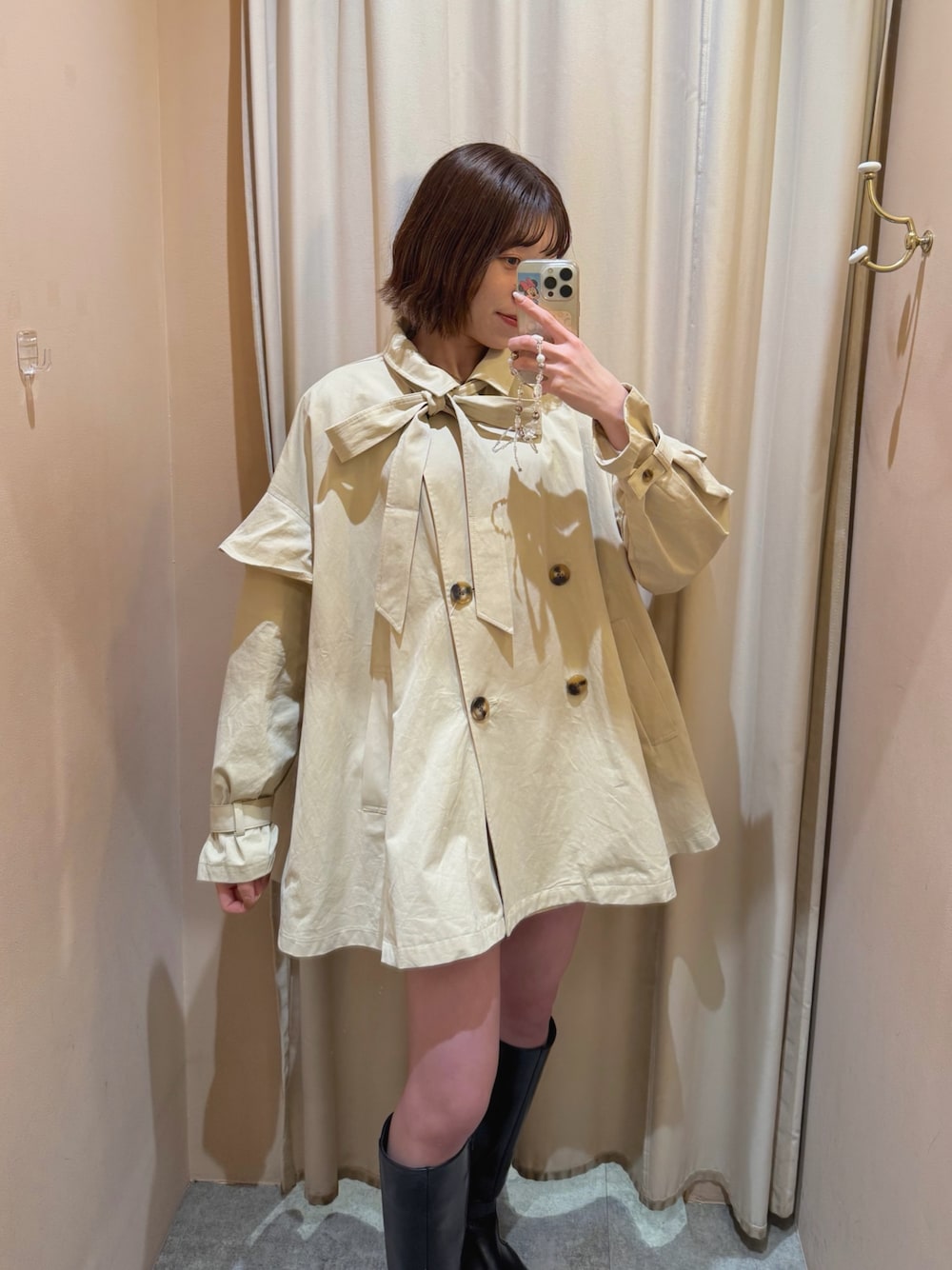 ベージュ系のトレンチコートを着用したレディースの春コーディネートの1枚目の写真