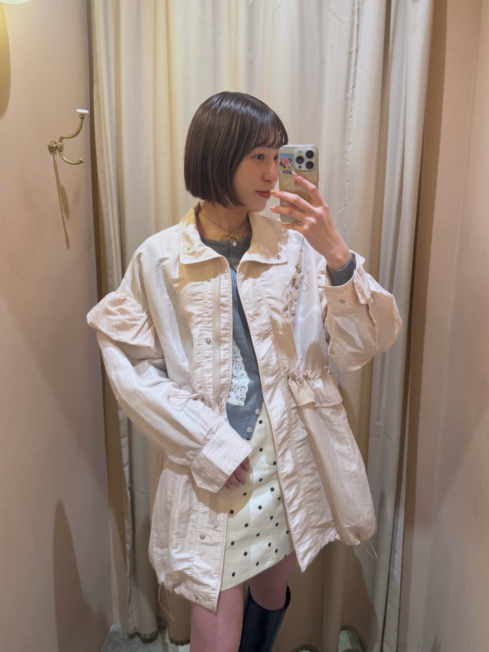 グレー系のカーディガン/ボレロ、ピンク系のブルゾン、ホワイト系のスカートを着用したレディースの冬コーディネートの1枚目の写真