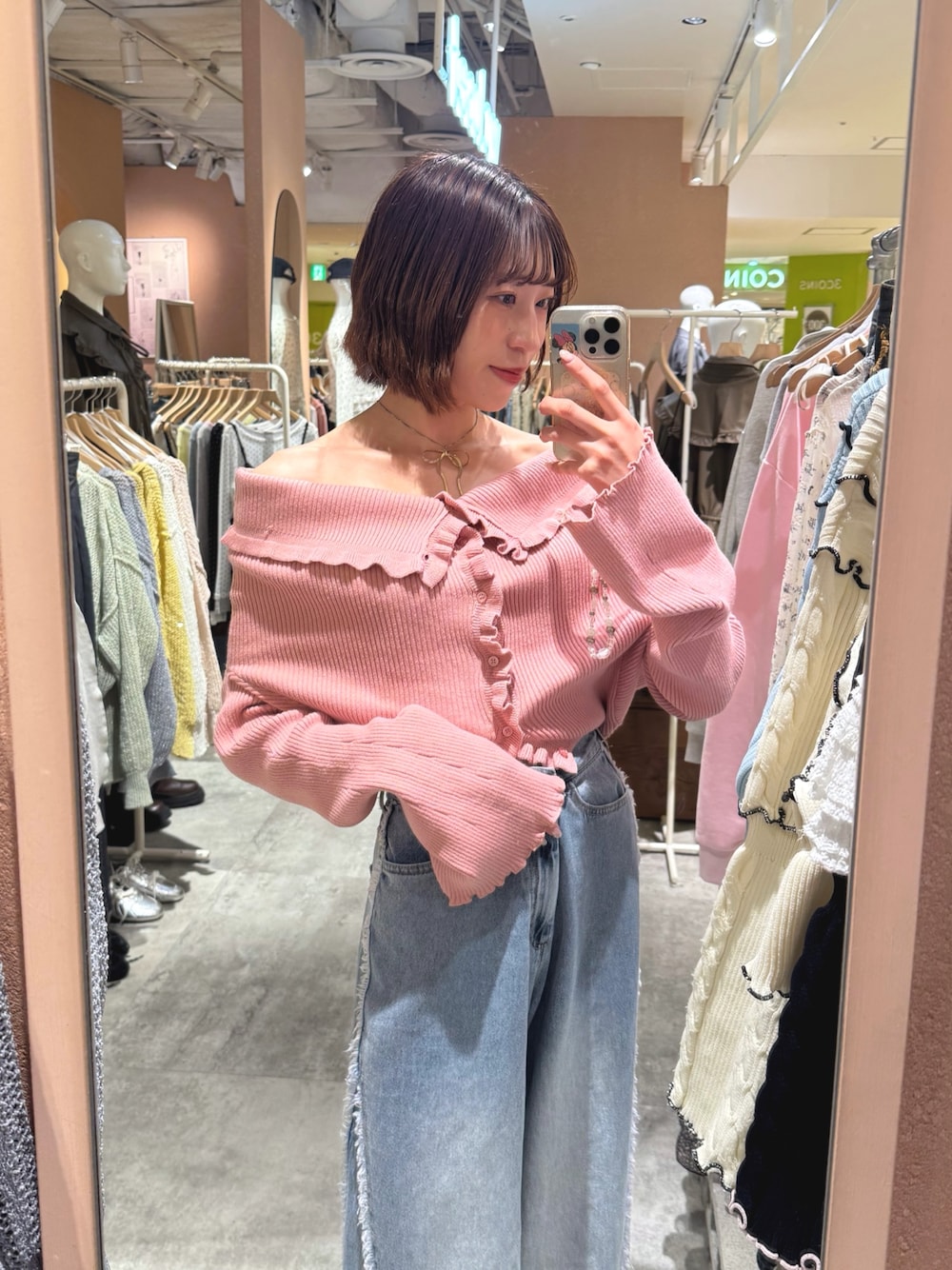 ピンク系のカーディガン/ボレロ、ブルー系のデニムパンツを着用したレディースの春コーディネートの1枚目の写真