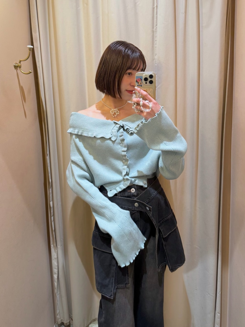 グリーン系のカーディガン/ボレロ、ブラック系のデニムパンツを着用したレディースの冬コーディネートの1枚目の写真