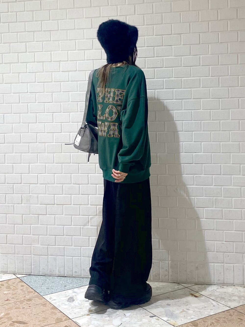 ブラック系のブーツ、ブラック系のスラックス、グレー系のショルダーバッグを着用したレディースの秋コーディネートの1枚目の写真