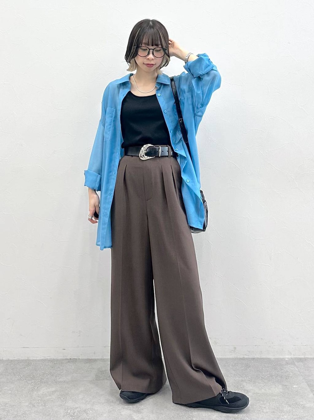 ブラック系のキャミソール、ブラック系のスニーカー、ブラック系のショルダーバッグを着用したレディースの春コーディネートの1枚目の写真