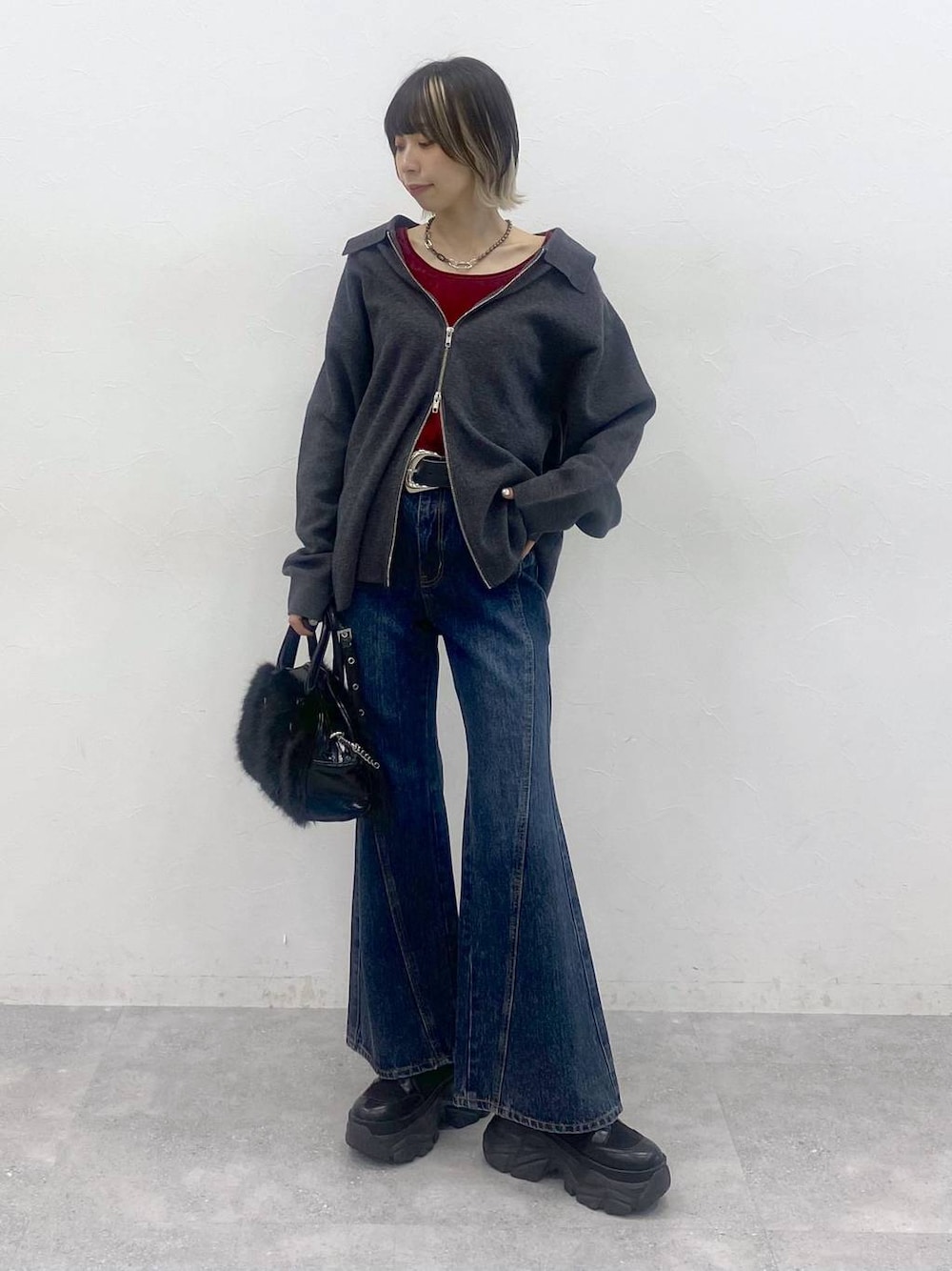 ブラック系のブーツ、ブルー系のデニムパンツ、レッド系のTシャツ/カットソーを着用したレディースの秋コーディネートの1枚目の写真