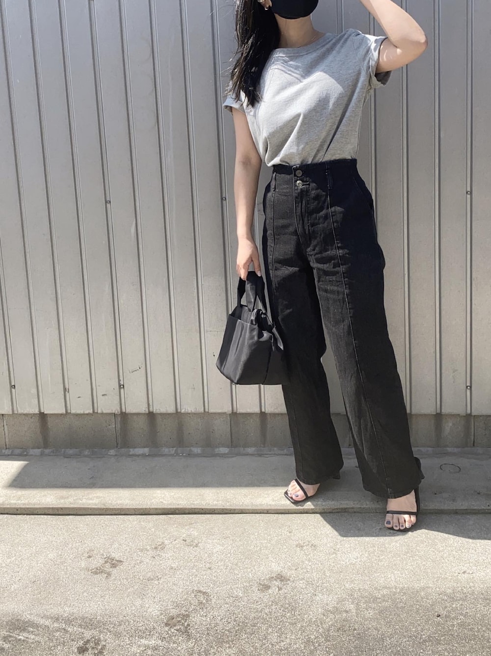 グレー系のTシャツ/カットソー、ブラック系のデニムパンツ、ブラック系のハンドバッグを着用したレディースの春コーディネートの1枚目の写真