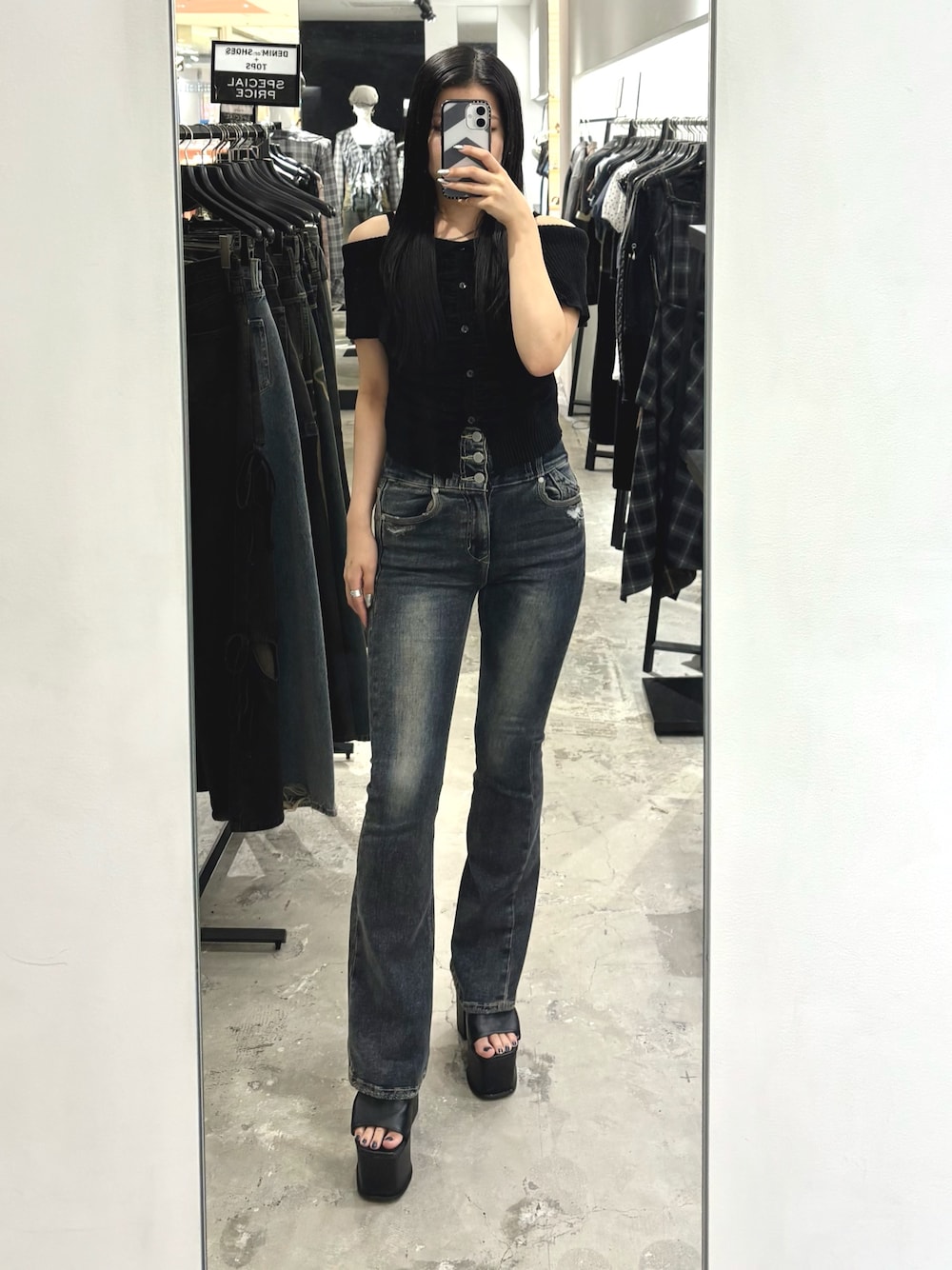 ブルー系のデニムパンツ、ブラック系のニット/セーター、ブラック系のサンダルを着用したレディースの夏コーディネートの1枚目の写真