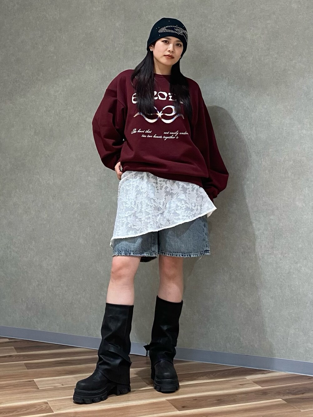 ホワイト系のスカート、ブルー系のデニムパンツ、ブラック系のブーツを着用したレディースの冬コーディネートの1枚目の写真