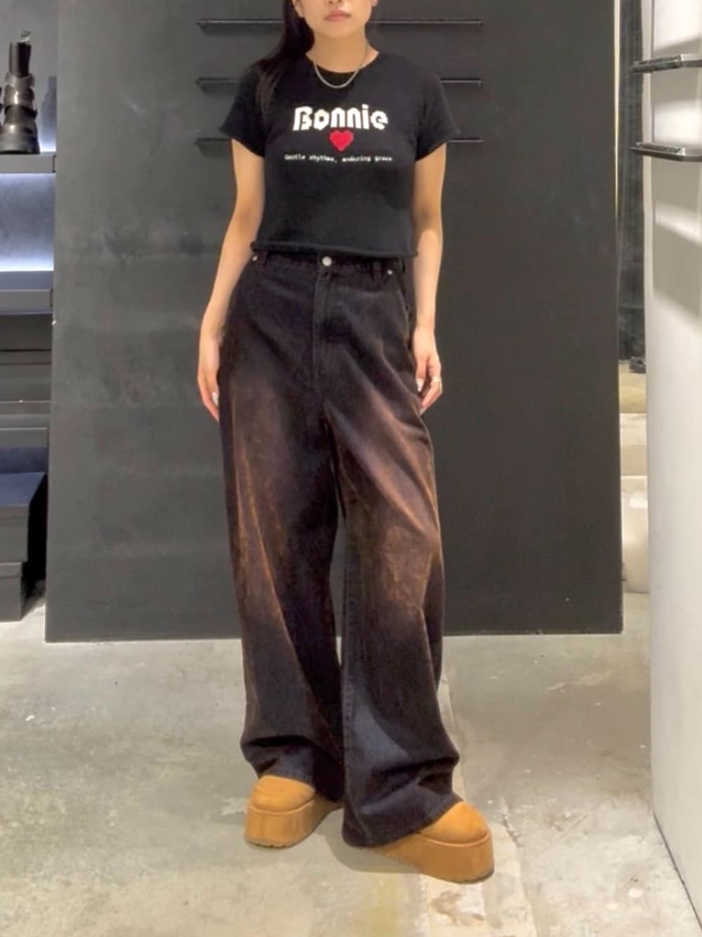 ブラック系のニット/セーター、ブラウン系のデニムパンツ、イエロー系のスリッポンを着用したレディースの夏コーディネートの1枚目の写真