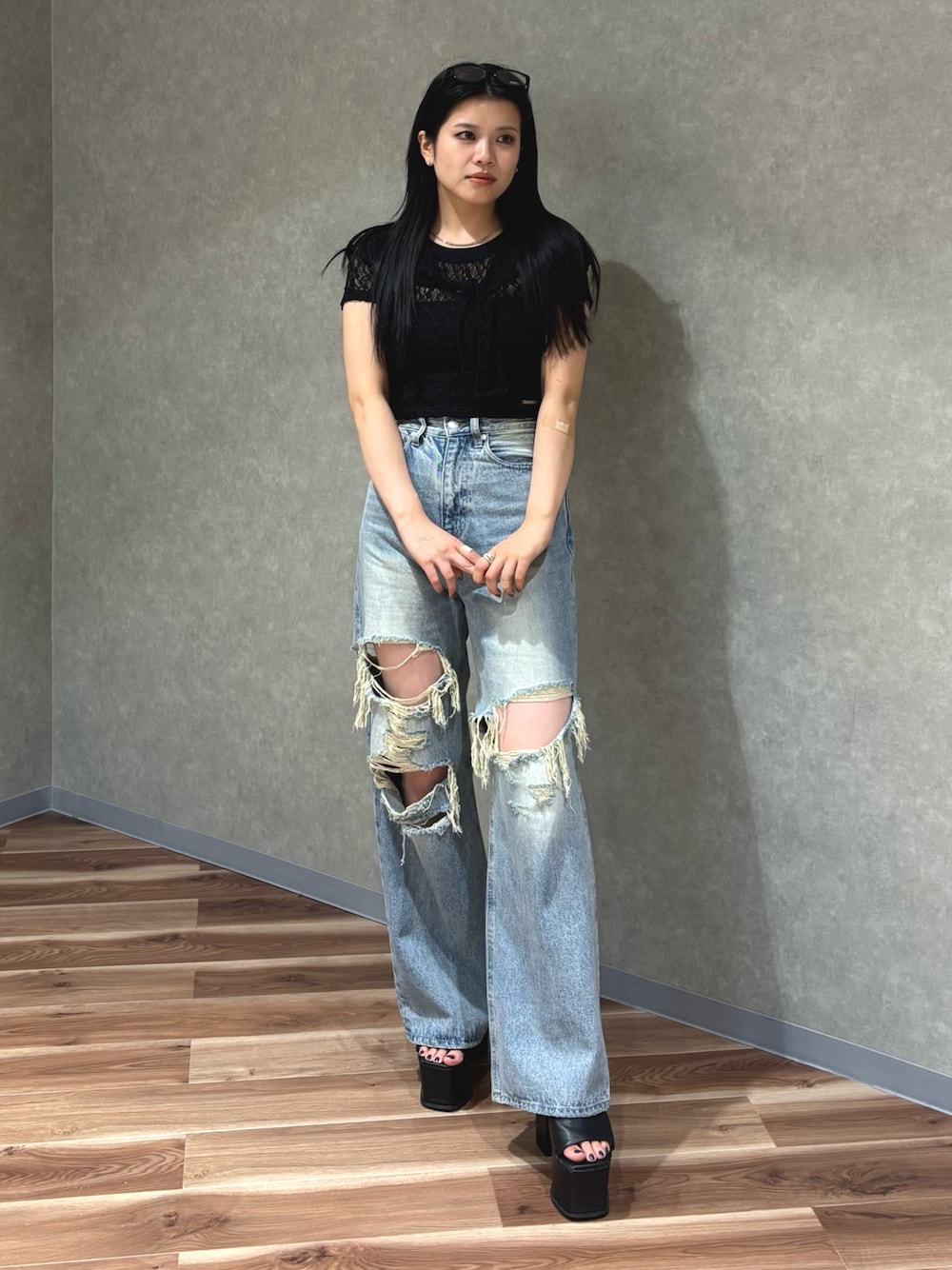 ブルー系のデニムパンツ、ブラック系のサンダル、ブラック系のTシャツ/カットソーを着用したレディースの夏コーディネートの1枚目の写真