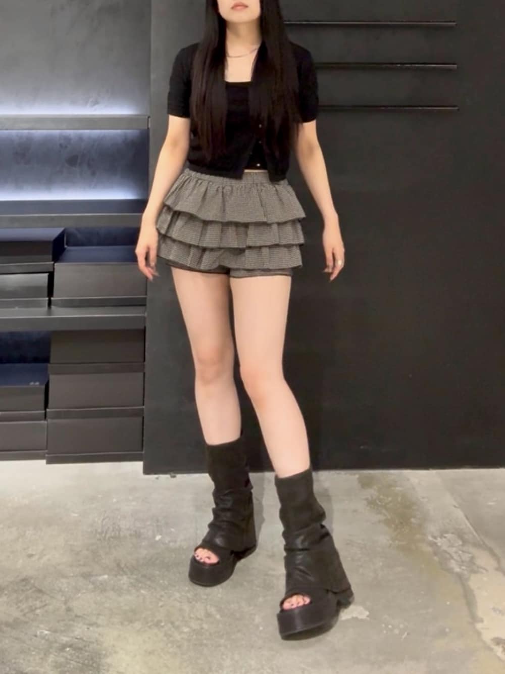 ベージュ系のスカート、ブラック系のニット/セーター、ブラック系のサンダルを着用したレディースの夏コーディネートの1枚目の写真