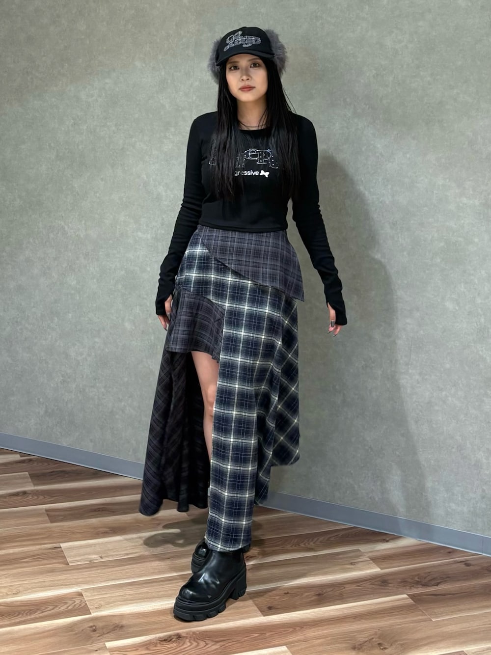 ブラック系のTシャツ/カットソー、ブルー系のスカート、ブラック系のブーツを着用したレディースの秋コーディネートの1枚目の写真